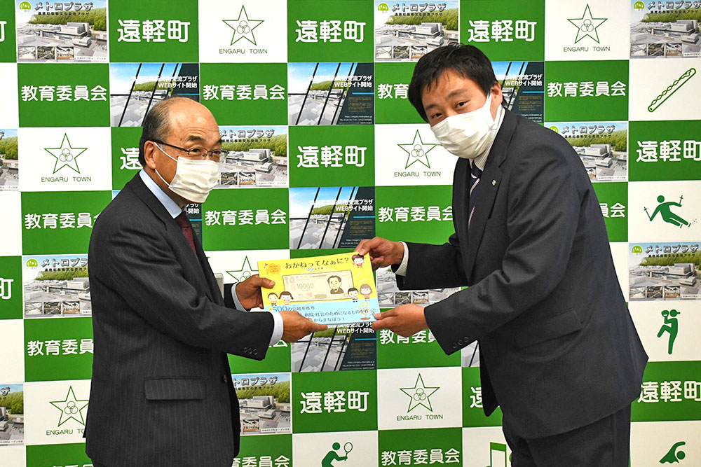 絵本を贈呈する小野康弘会長（写真右）と河原英男教育長（写真左）