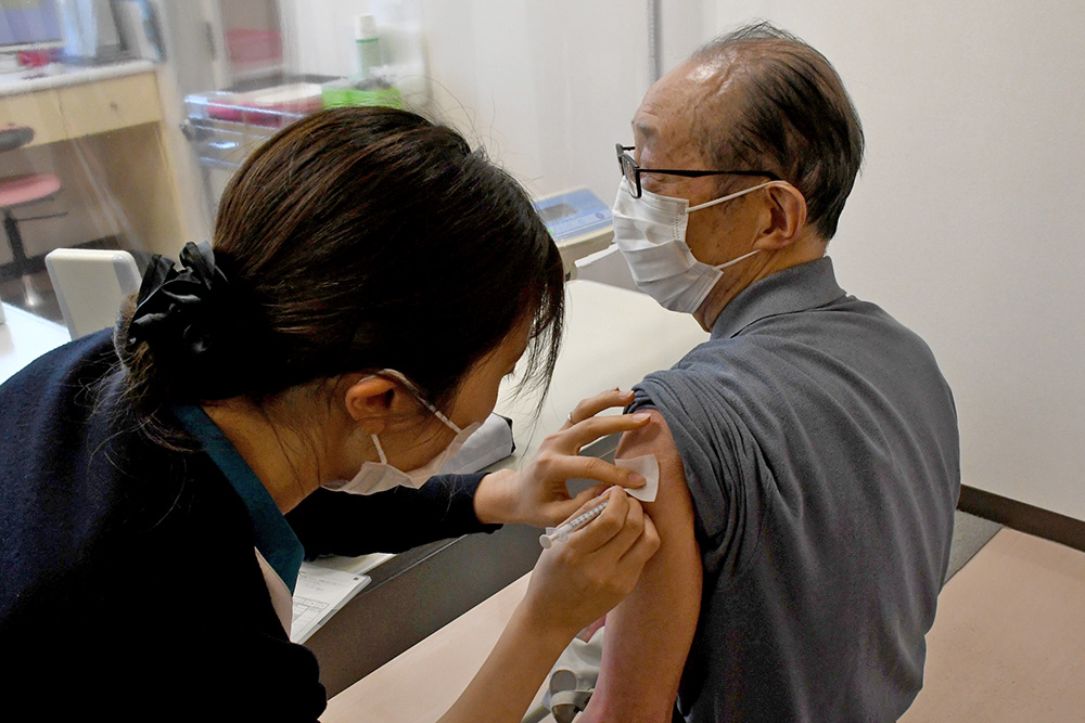 新型コロナウイルスワクチンを接種する男性