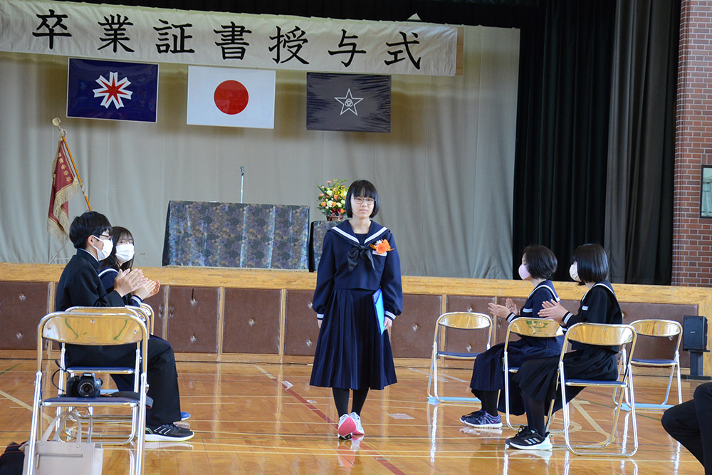 卒業証書を手に会場を後にする生徒