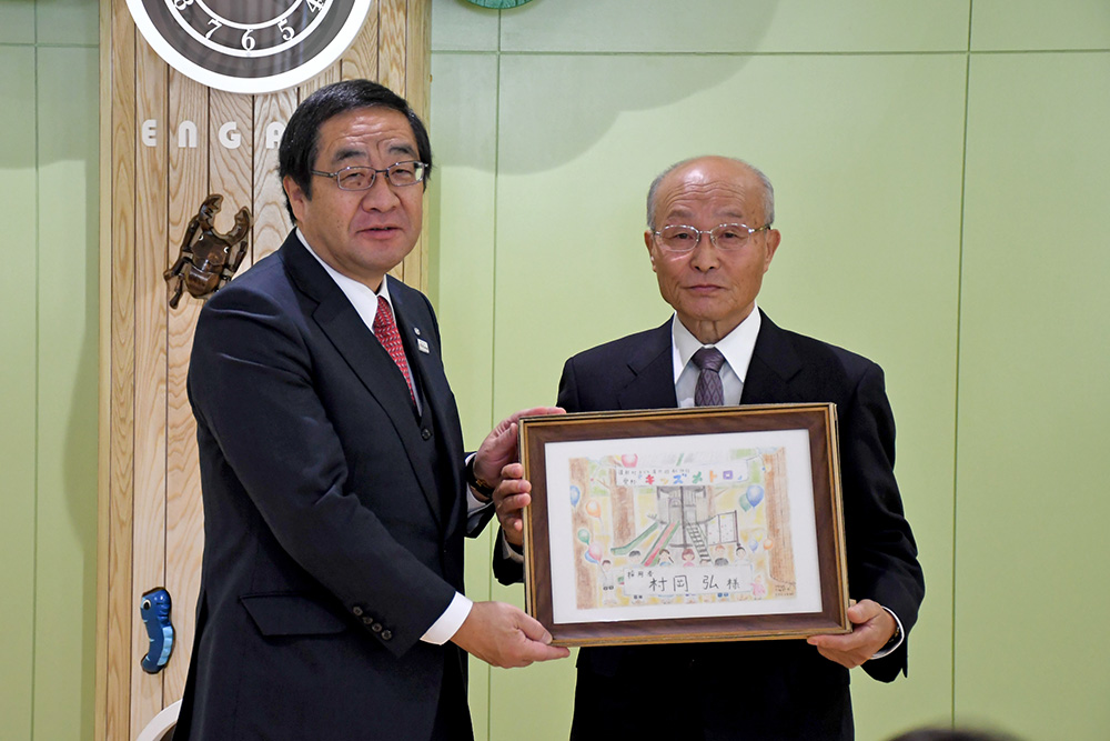 記念品を受け取る村岡弘さん（写真右）と佐々木修一遠軽町長（写真左）