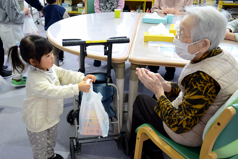 防火啓発グッズを手渡す子どもたち