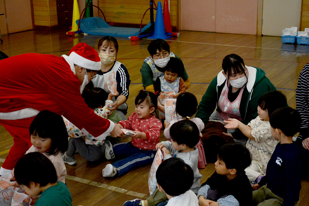 サンタさんからクリスマスプレゼントをもらう子どもたち