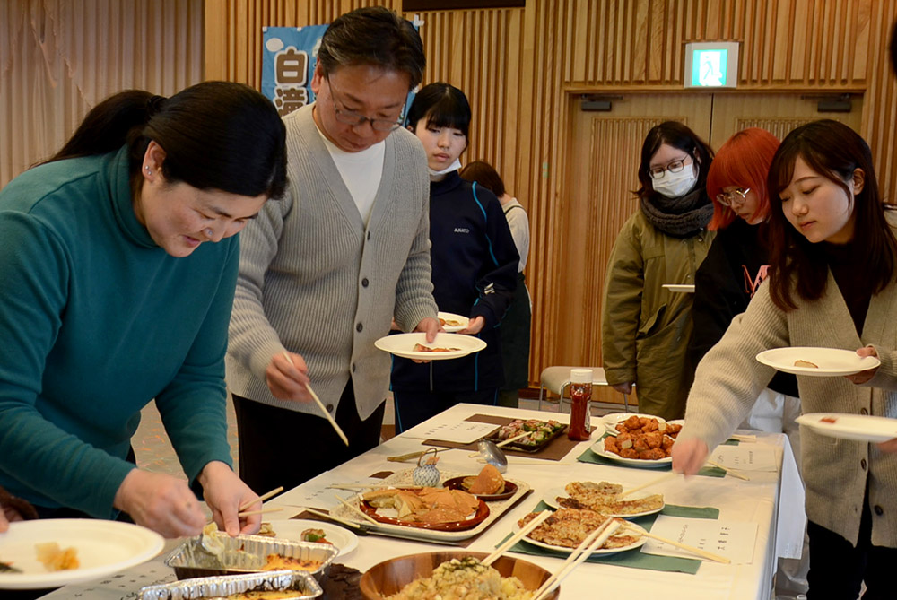 互いの料理を試食して交流を深める参加者